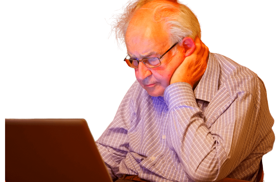 Dementia Care Plan: Elderly man focused on a laptop, actively engaging with the Voise Foundation's online resources.